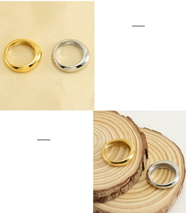 Polished stainless steel wide rings in gold and silver finish shown on wooden surface