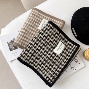 Detailed texture of houndstooth knit scarves in brown and black-white on soft fabric