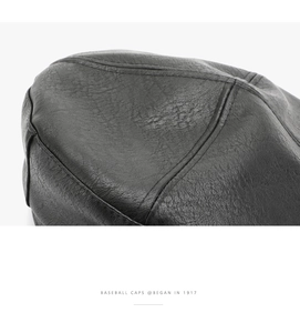 Close-up of black PU leather texture and fine stitching on a vintage octagonal cap