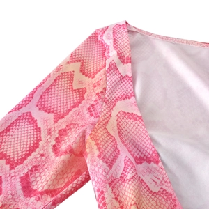 Detailed macro view of pink snakeskin print texture and neckline stitching quality