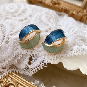 Vintage geometric enamel stud earrings in blue and green on lace background