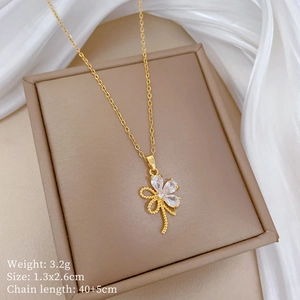 Detail eines goldenen Blumenanhängers mit Zirkonia-Blütenblättern und Schleife auf Box