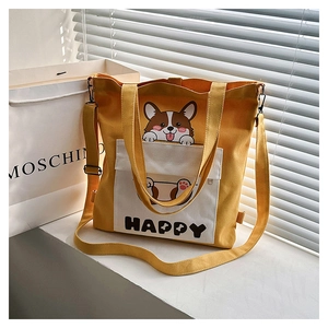 Detail of yellow canvas tote bag featuring cute corgi print and adjustable shoulder strap
