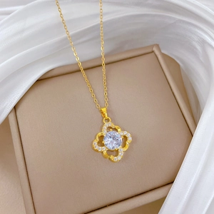 Macro detail of gold four-leaf clover pendant necklace with sparkling zircon stones