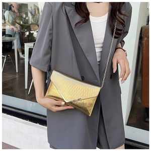 Gros plan sur la pochette enveloppe dorée avec texture plissée et chaîne en métal
