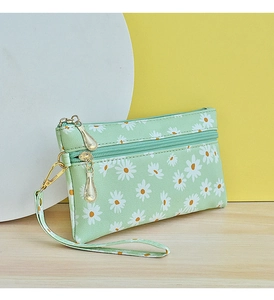 Detailed shot of mint green daisy pattern fabric on small double zipper wristlet bag