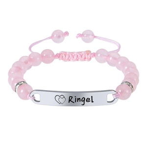 Détail du bracelet bébé en cristal rose avec plaque gravée et motif de double coeur