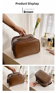 Close-up of brown leather toiletry bag with sturdy handle and dual metal zippers