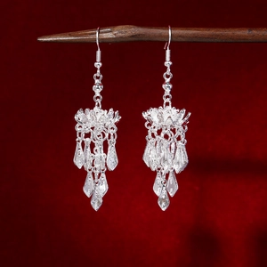 Detailed close-up of vintage silver ethnic earrings with delicate flower tassel design