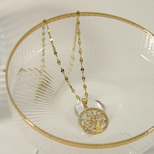 Elegant gold Tree of Life pendant necklace with sparkling cubic zirconia on glass edge