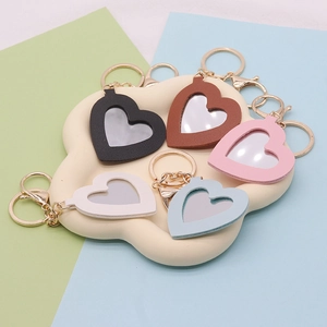 Five colorful PU leather heart-shaped mirror keychains in pastel tones with gold metal clips