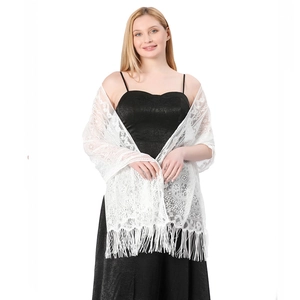 Close-up of white lace shawl with intricate floral hollow pattern and long fringe trim