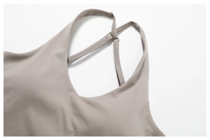 Detailed view of grey yoga top featuring criss-cross back straps and elastic fabric