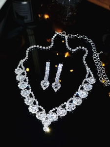 Detailed view of luxury silver bridal jewelry set with floral zircon necklace and earrings