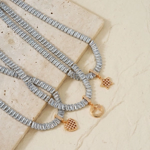 Detail of elegant necklaces featuring gold stars and heart charms with silver square zircons