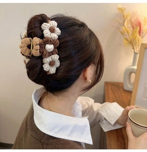 Detail of hand-crocheted floral hair claw clip in beige and coffee brown tones