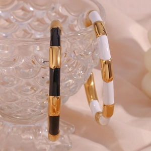 Detail of bamboo joint bangles in black and white enamel with 18K gold plated finish