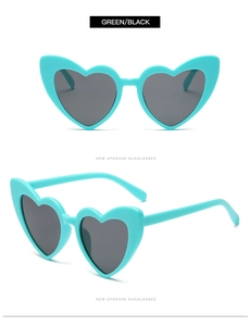 Detail view of heart-shaped sunglasses in mint green with dark black lenses