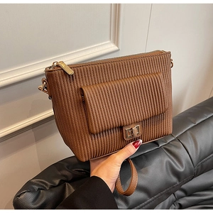 Detail view of brown pleated crossbody bag with gold metal square lock and chain strap