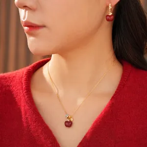 Set collana e orecchini a forma di mela placcati in oro 18k indossati dalla modella