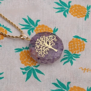 Detail of tree of life pendant featuring amethyst chips and golden twisted chain