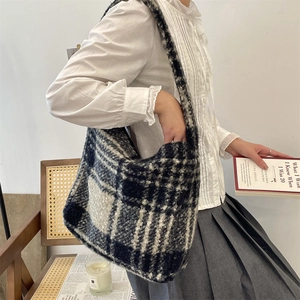 Close-up of black and white checkered plush tote bag with cozy autumn reading scene