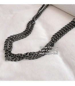 Detail of dark grey metal chain strap with double row link design for handbag
