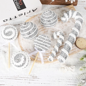 Christmas foam ornaments set with silver glitter balls, candy canes and lollipops on snow