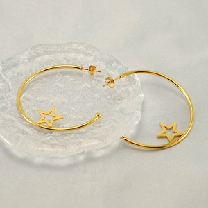 Fashionable gold stainless steel hoop earrings with hollow star pendants on gray background