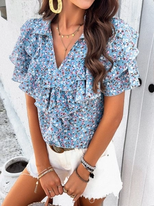 Detail of blue floral print V-neck shirt with ruffle trim and elegant short sleeves