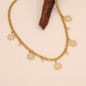 Gros plan d'un collier étoile à huit branches doré avec strass blancs sur tissu