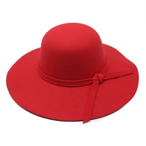 Detail of red wool felt fedora featuring a matching ribbon band and round brim