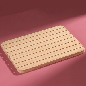 Rectangular solid wood display tray with parallel slots on a pink background