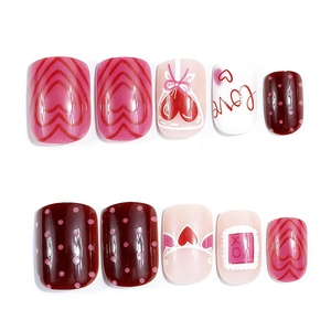 Detail of glossy press-on nails with heart, dots, and Love patterns for Valentine's Day