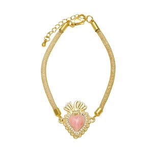 Detalle de la pulsera de malla dorada con dije de corazón rosa, corona y circonitas brillantes