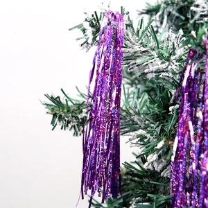 Close-up of sparkling purple tinsel on a snowy Christmas tree branch for party decoration