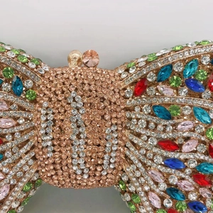 Macro shot of colorful rhinestones on a gold bow clutch evening bag with metal frame
