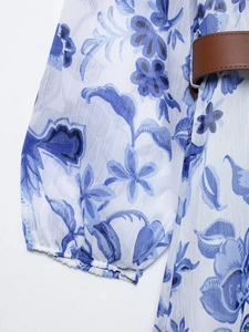 Détails de la robe en mousseline à imprimé floral bleu avec une ceinture en cuir marron