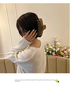 Matte khaki hair claw clip for large hair styles shown on model in cozy setting