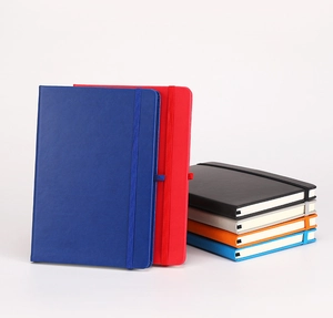 Side view of stacked hardcover notebooks showing elastic closure bands and various colors