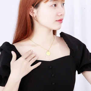 Elegant gold-plated stainless steel Pisces zodiac coin necklace worn by female model