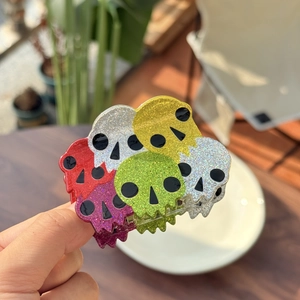 Macro shot of colorful glittery skull claw clip featuring vibrant acrylic texture