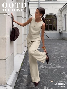 Detail of beige suit vest set with metallic buttons and wide leg pants for a chic look