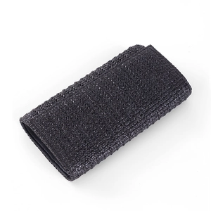 Detail of black woven texture on a minimalist vacation style crossbody clutch bag