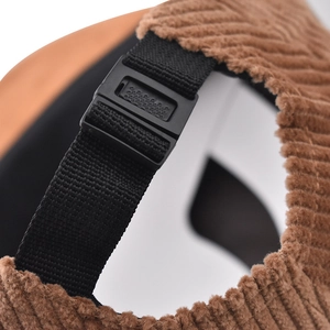 Close-up of the adjustable black strap and buckle on the brown corduroy baseball cap