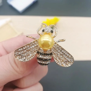 Close-up of a honey bee brooch with yellow pearl and sparkling rhinestones