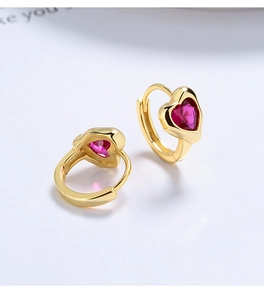 Detail of 925 silver gold-plated heart earrings with inset red zircon stones