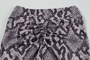 Detail view of high-waist yoga pants with scrunch butt design and snakeskin pattern