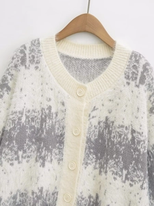 Close-up of fuzzy gray gradient knit cardigan with V-neck and cream buttons