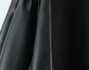 Detail of black PU leather stitching with lychee texture and fine seams on the dress